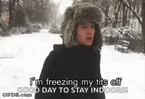 A Man Wearing A Fur Hat Is Standing In The Snow And Saying `` I 'M Freezing My Tits Off . GIF