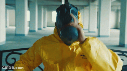A Man Wearing A Gas Mask And A Yellow Jacket That Says ' Puma ' On The Sleeve GIF