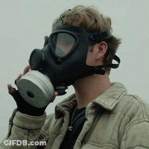A Man Wearing A Gas Mask And Gloves GIF