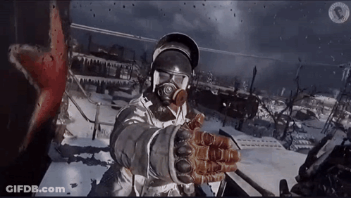 A Man Wearing A Gas Mask And Gloves Stands In The Snow GIF