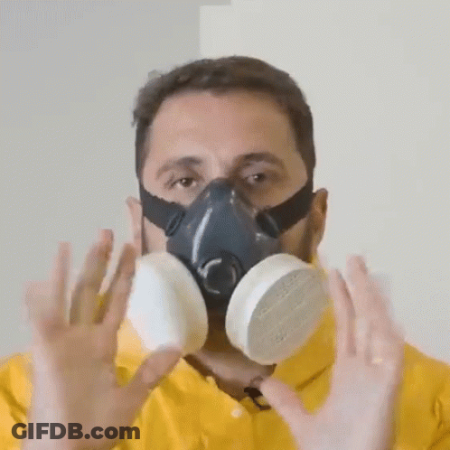 A Man Wearing A Gas Mask Holds His Hands Up GIF