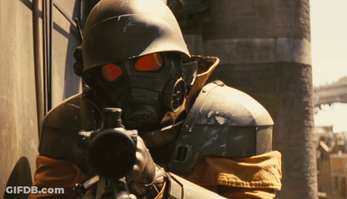 A Man Wearing A Gas Mask Is Holding A Rifle GIF