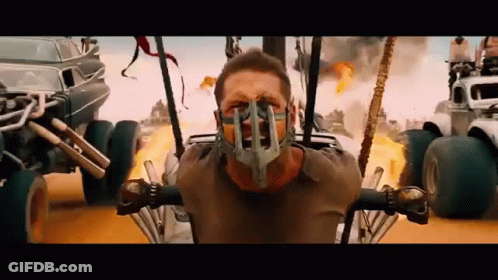 A Man Wearing A Gas Mask Is Sitting In A Buggy In A Movie . GIF