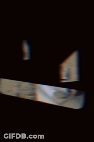A Man Wearing A Gas Mask Is Sitting In Front Of A Brick Building GIF