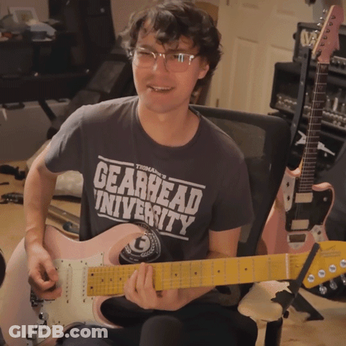 Man Playing Pink Guitar In Gearhead Shirt GIF