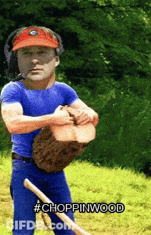 A Man Wearing A Georgia Bulldogs Hat Is Holding A Log And A Shovel With The Words Choppinwood Below Him GIF