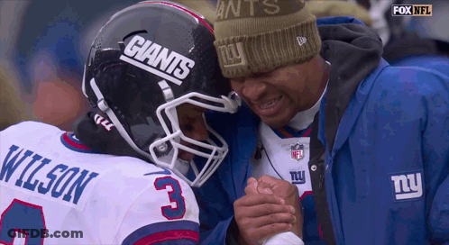 A Man Wearing A Giants Hat Talks To A Player GIF