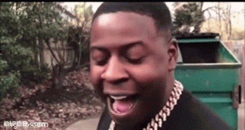 A Man Wearing A Gold Chain Around His Neck Is Laughing With His Mouth Open . GIF