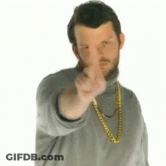 A Man Wearing A Gold Chain Around His Neck Is Pointing At The Camera GIF