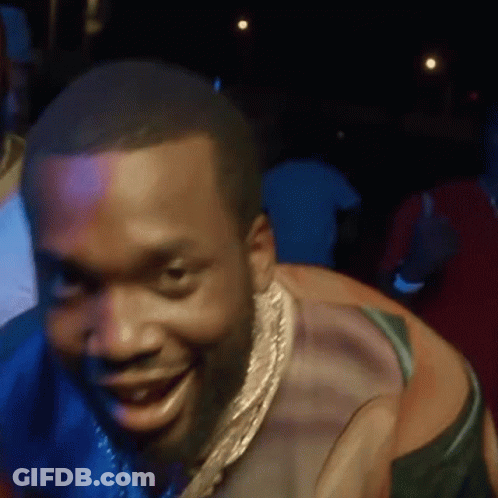 A Man Wearing A Gold Chain Around His Neck Is Smiling . GIF