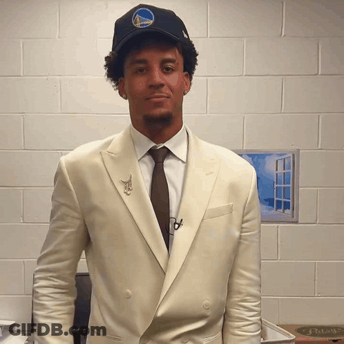A Man Wearing A Golden State Warriors Hat And Suit GIF