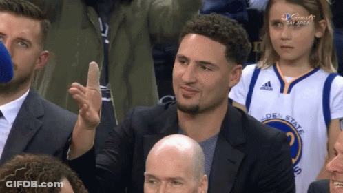 A Man Wearing A Golden State Warriors Jersey Is Giving A High Five GIF