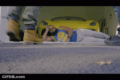 A Man Wearing A Golden State Warriors Shirt Lays On The Ground GIF