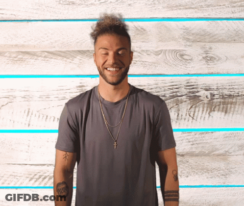 A Man Wearing A Gray Shirt And A Gold Cross Necklace Smiles With His Eyes Closed GIF