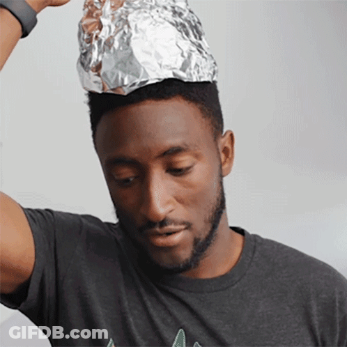 A Man Wearing A Gray Shirt Has A Piece Of Aluminum Foil On Top Of His Head GIF