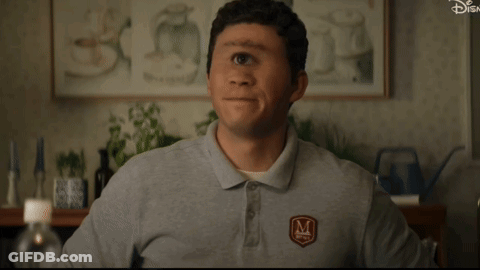 A Man Wearing A Gray Shirt With The Letter M On The Front GIF