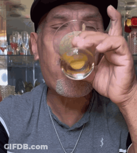 A Man Wearing A Gray Shirt With The Letter S On It GIF