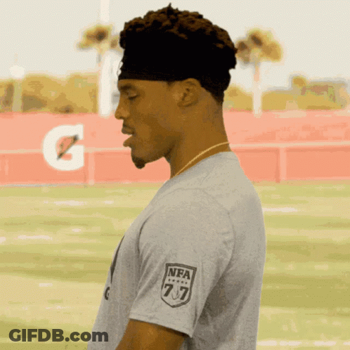 A Man Wearing A Gray T-Shirt With The Nfl Logo On His Sleeve GIF