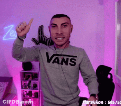 A Man Wearing A Gray Vans Sweatshirt Is Giving A Thumbs Up GIF