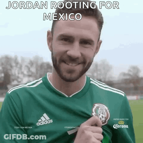 A Man Wearing A Green Adidas Jersey Is Holding A Trophy . GIF