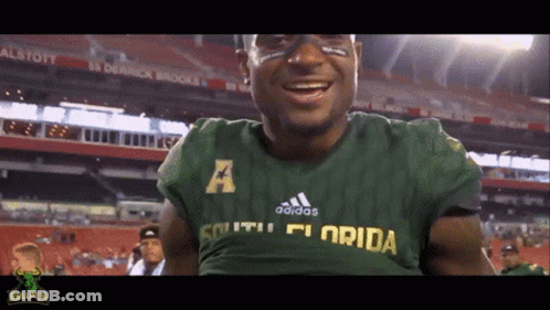 A Man Wearing A Green Adidas South Florida Shirt GIF