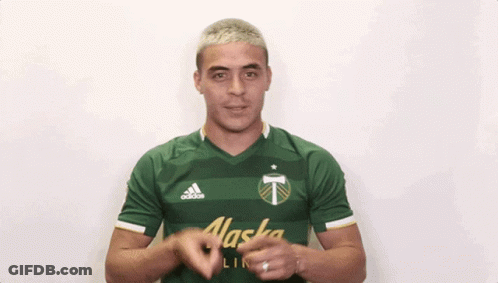 A Man Wearing A Green Alaska Shirt Is Clapping His Hands GIF
