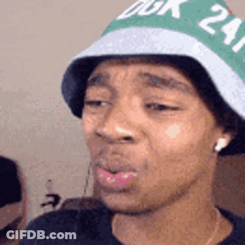 A Man Wearing A Green And White Hat With The Number 24 On It . GIF