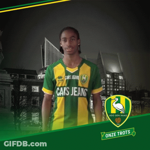 A Man Wearing A Green And Yellow Cats Jeans Shirt GIF