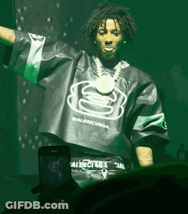 A Man Wearing A Green Balenciaga Shirt Stands In Front Of A Phone GIF