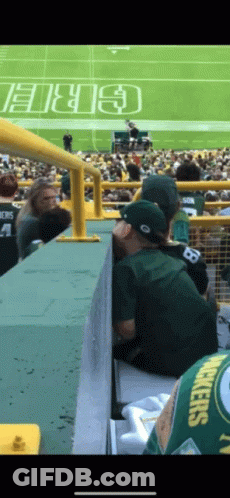 A Man Wearing A Green Bay Packers Jersey Sits On A Bleacher GIF