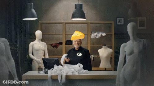 A Man Wearing A Green Bay Packers Shirt Holds A Receipt And A Piece Of Cheese On His Head GIF
