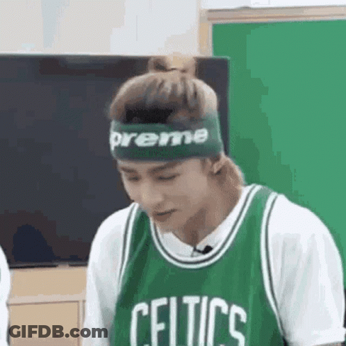 A Man Wearing A Green Celtics Jersey And A Green Headband Is Looking Down . GIF