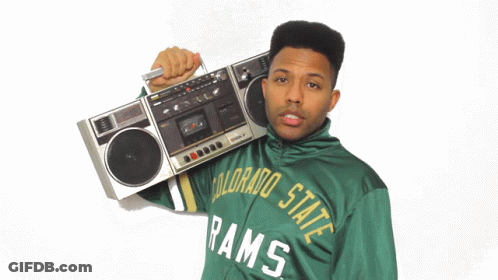 A Man Wearing A Green Colorado State Rams Jacket Is Holding A Boombox Over His Shoulder GIF