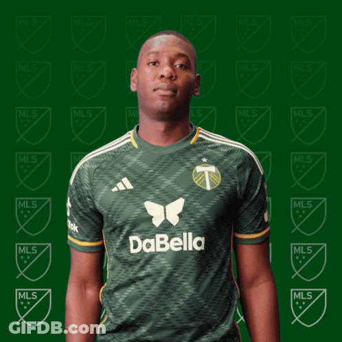 A Man Wearing A Green Dabella Jersey Stands In Front Of A Green Background GIF