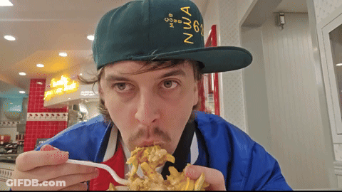 A Man Wearing A Green Hat With The Number 6 On It Is Eating French Fries GIF