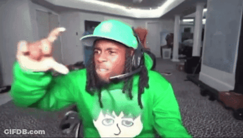 A Man Wearing A Green Hoodie And A Blue Hat Is Giving A Thumbs Up GIF
