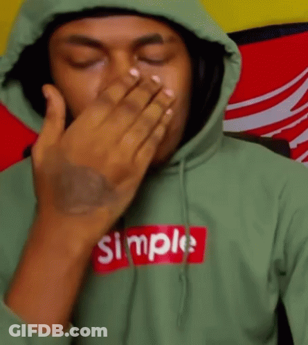 A Man Wearing A Green Hoodie With The Word Simple On It Covering His Mouth With His Hand . GIF