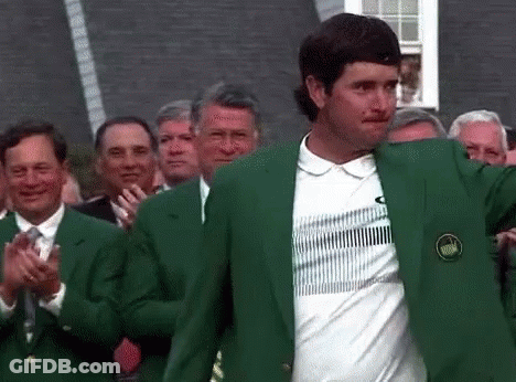 A Man Wearing A Green Jacket And A White Shirt Is Standing In Front Of A Crowd Of People Applauding . GIF