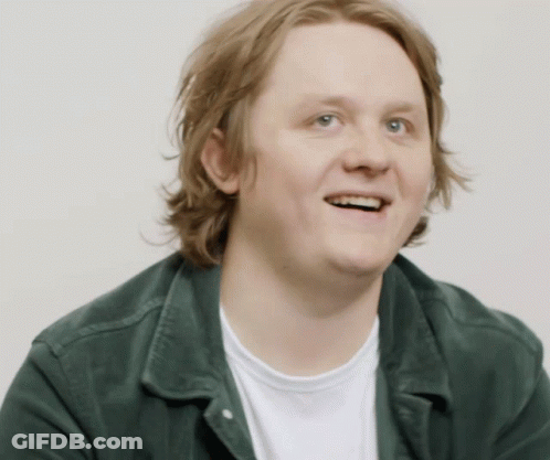 A Man Wearing A Green Jacket And A White Shirt Smiles For The Camera GIF