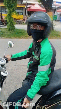 A Man Wearing A Green Jacket That Says Grab Is Sitting On A Motorcycle GIF