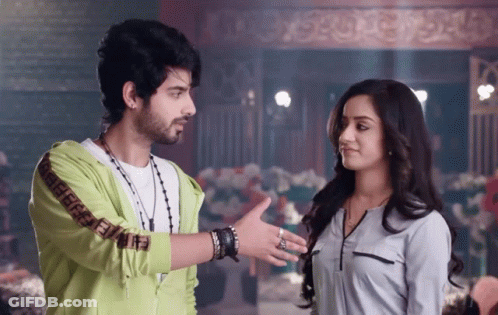 A Man Wearing A Green Jacket With The Letters Ff On The Sleeves Talks To A Woman GIF