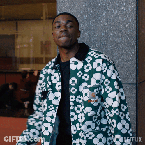 A Man Wearing A Green Jacket With White Flowers Has A Netflix Logo On The Bottom Right GIF