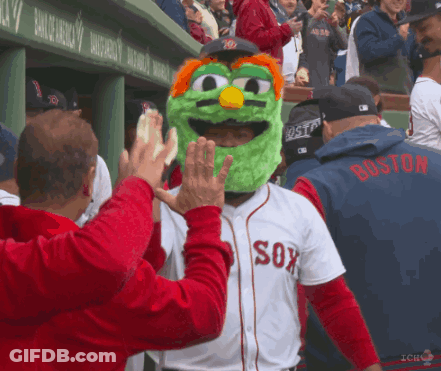 A Man Wearing A Green Mascot Mask And A Boston Jersey High Fives Another Man GIF