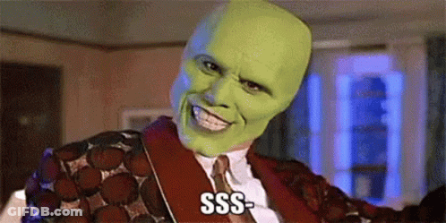 A Man Wearing A Green Mask And A Red Jacket Is Smiling And Saying Sss . GIF