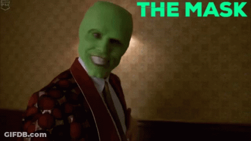 A Man Wearing A Green Mask Is Smiling With The Words The Mask Behind Him GIF