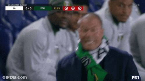 A Man Wearing A Green Scarf Is Watching A Soccer Game On Tv GIF
