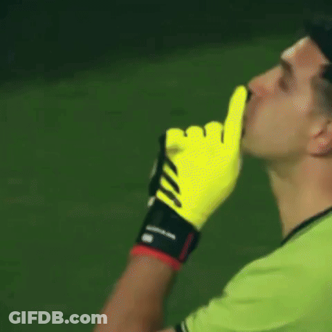 A Man Wearing A Green Shirt And Yellow Adidas Gloves Holds His Finger To His Mouth GIF