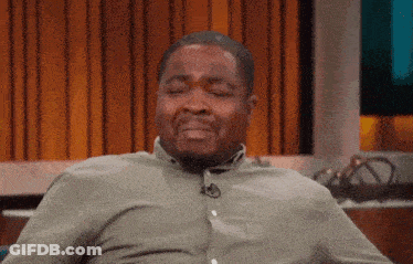 A Man Wearing A Green Shirt Is Sitting With His Eyes Closed GIF