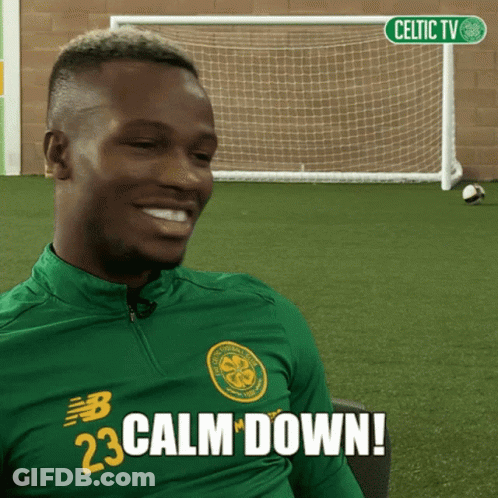 A Man Wearing A Green Shirt That Says Calm Down On It GIF