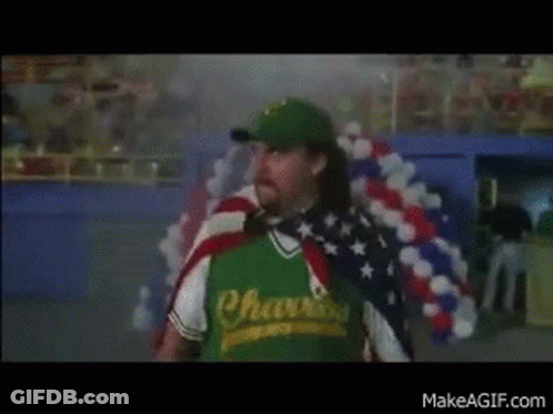A Man Wearing A Green Shirt That Says Chasers Is Holding An American Flag Around His Neck . GIF